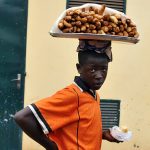 un giovane venditore ambulante di pane in una via a yaoundè in camerun