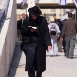 Israele, ebreo ortodosso intento nella lettura in un via di Gerusalemme