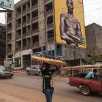 un giovane venditore ambulante di occhilali da sole in una via di Yaounde in camerun